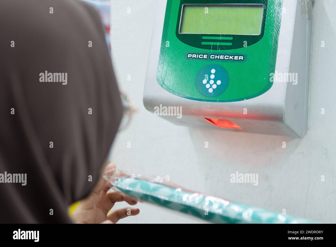 Image rapprochée du client utilisant le vérificateur de prix au supermarché. Banque D'Images