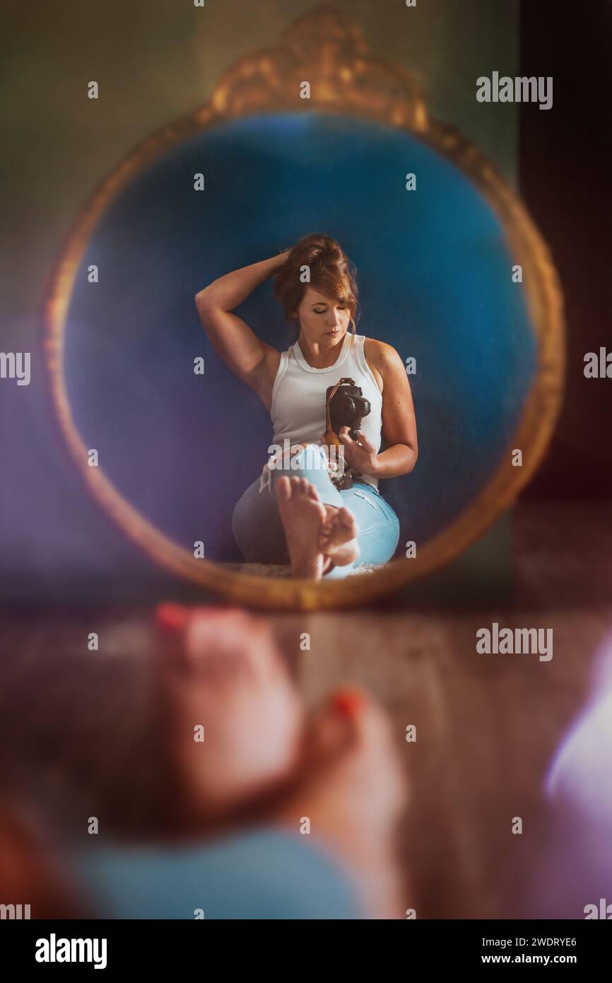 Femme prenant la photo de son reflet dans le miroir Banque D'Images