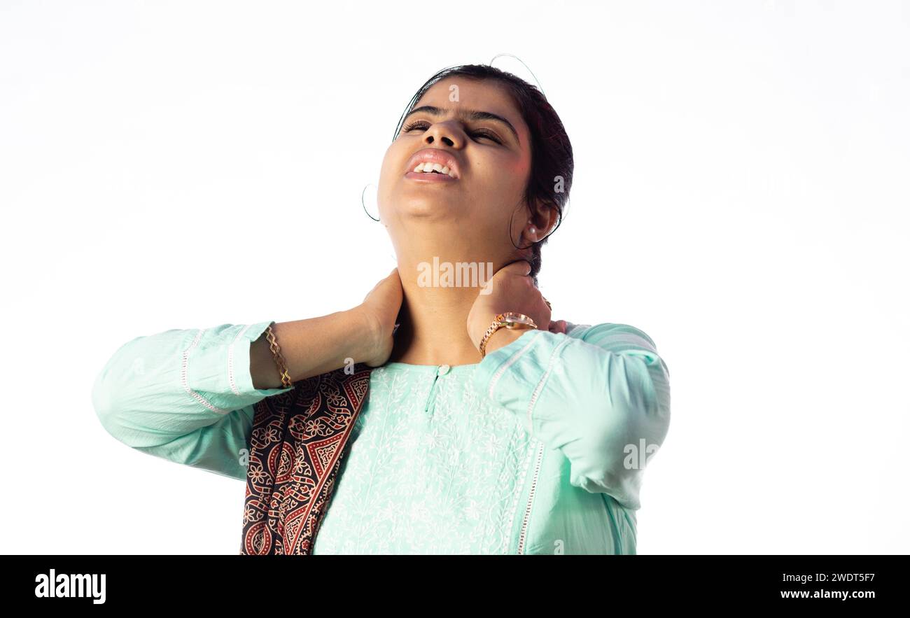 Une femme indienne tenant son cou pour la douleur montrant une expression douloureuse sur fond blanc Banque D'Images