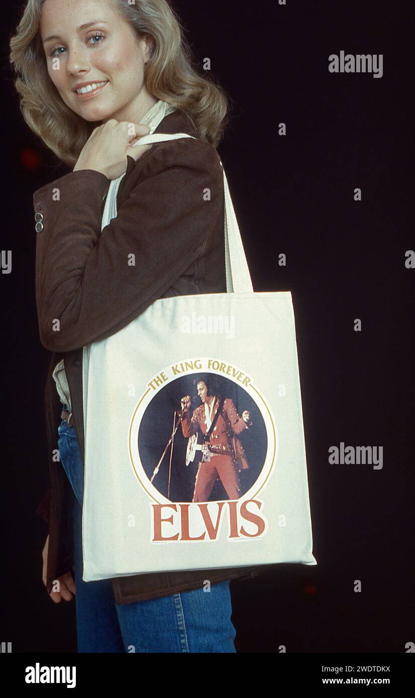 Un joli modèle porte un sac fourre-tout Elvis Presley qui le proclame « le Roi pour toujours ». Dans un studio New-yorkais à la fin des années 1970 Banque D'Images