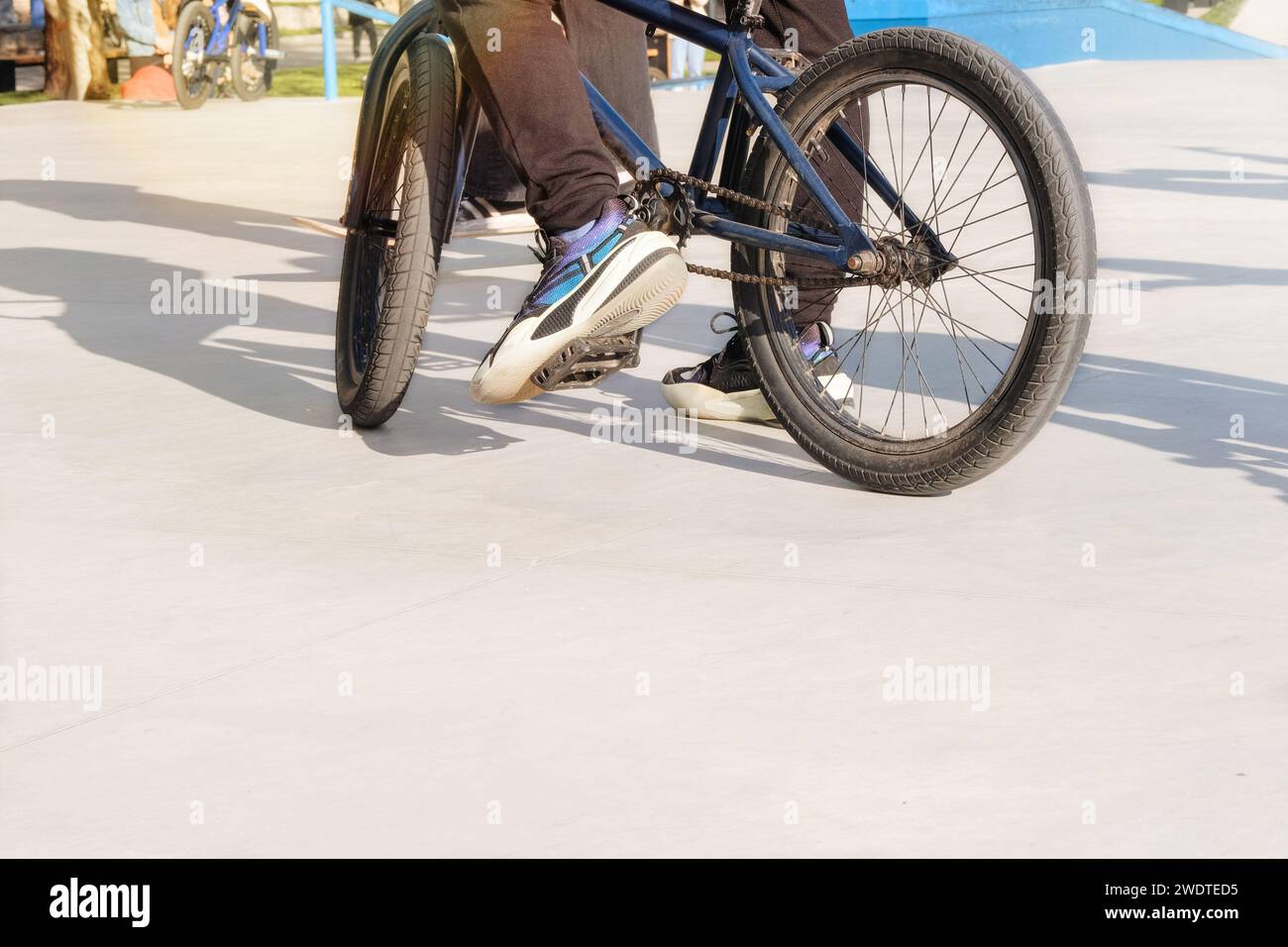 Vie urbaine active. Vélo extrême ayant du plaisir à pratiquer à la rampe de skatepark dans la journée ensoleillée d'été dans la ville. Sous-culture urbaine. Banque D'Images