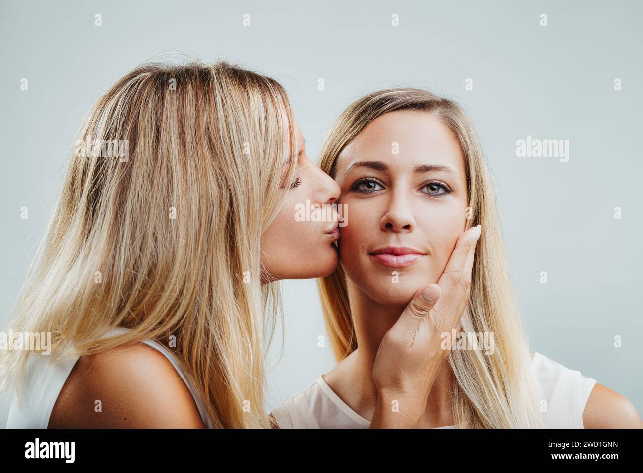 scène tendre de l'amitié, comme une femme blonde embrasse affectueusement son compagnon Banque D'Images