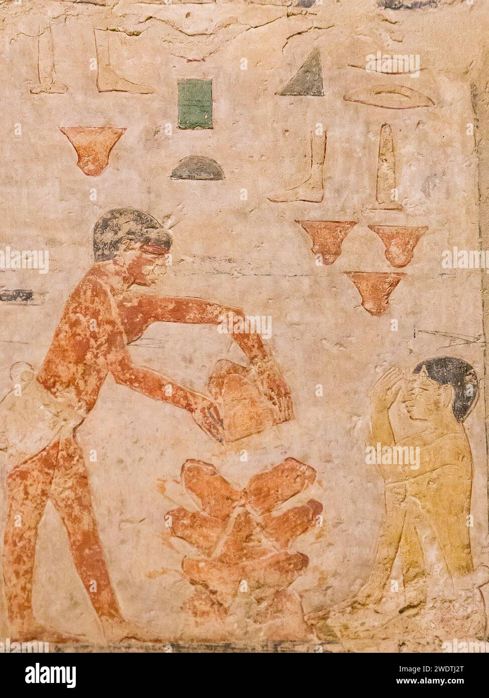 Egypte, Saqqara, tombeau de Ty, scènes de boulangerie : chauffer des pots vides, qui serviront de mini-fours. Protéger le visage de la chaleur, avec le bras. Banque D'Images