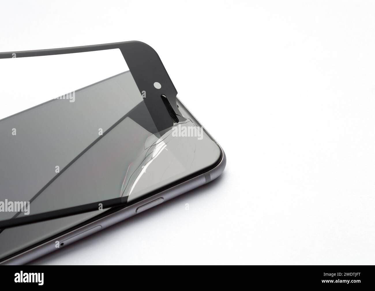 Processus de remplacement du verre de protection sur smartphone sur fond blanc. Verre de sécurité avec fissures. Banque D'Images