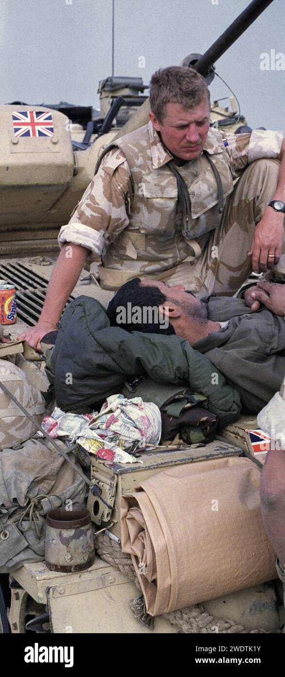 2 mars 1991 dans le nord du Koweït, un soldat britannique des Queen's Dragoon Guards s'occupe d'un prisonnier de guerre irakien au sommet d'un char Scimitar. Banque D'Images