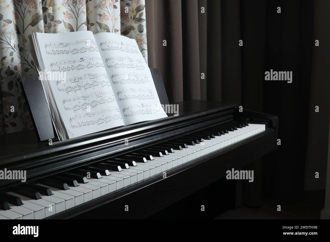 piano noir et partitions, à la maison. Photo de haute qualité Banque D'Images