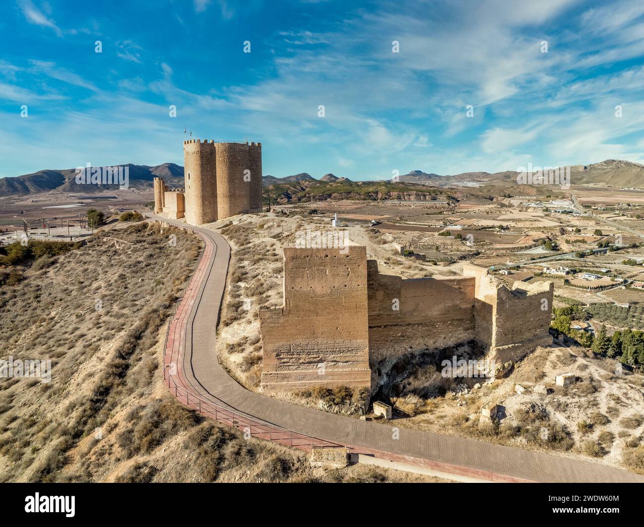 Vue aérienne du château médiéval Jumilla à Murcie Espagne, sur une colline, imposant donjon de forme irrégulière avec quatre étages, créneaux crénelés bl nuageux Banque D'Images