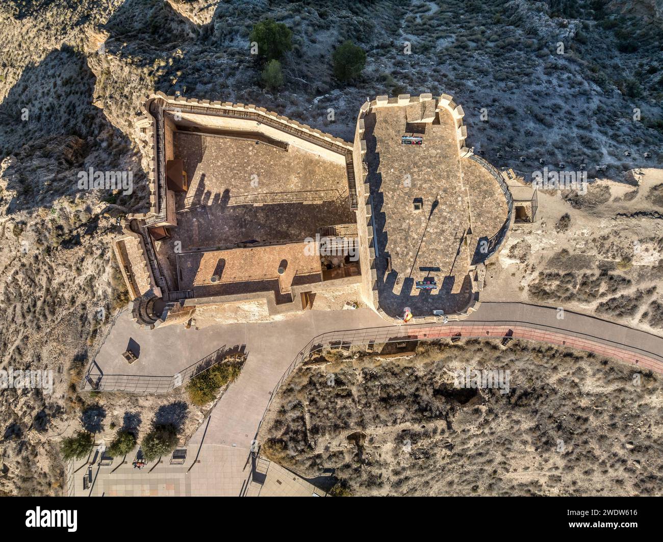Vue aérienne du château médiéval Jumilla à Murcie Espagne, sur une colline, imposant donjon de forme irrégulière avec quatre étages, créneaux crénelés bl nuageux Banque D'Images