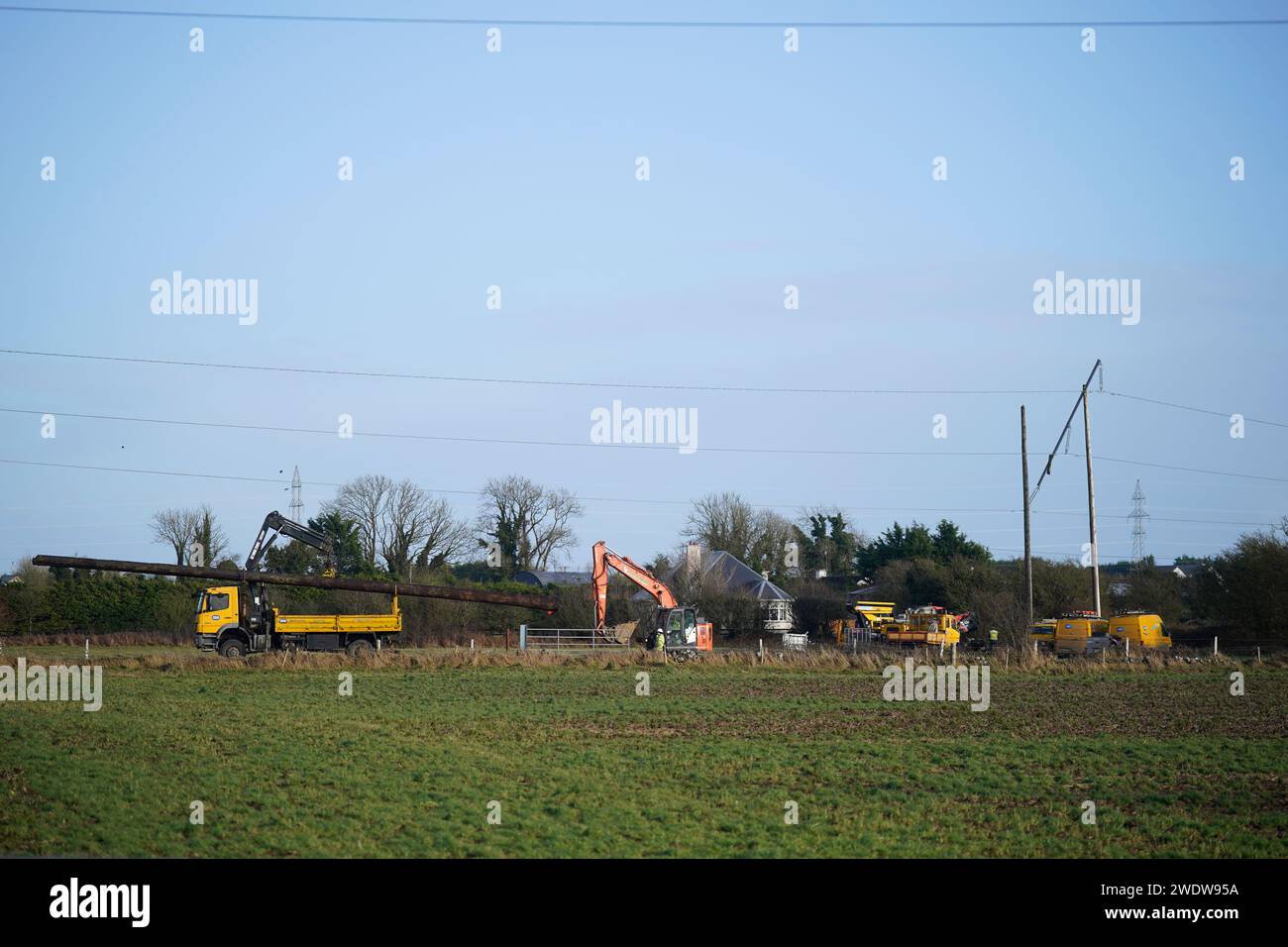 Les équipes d'ESB Networks remplacent les pylônes électriques tombés dans un champ près de l'aéroport de Galway après qu'ils aient été endommagés pendant la tempête Isha. Les avertissements les plus sévères des prévisionnistes ont été levés après que les vents forts de la tempête Isha ont perturbé les compagnies aériennes et touché les alimentations électriques à travers l'île. Date de la photo : lundi 22 janvier 2024. Banque D'Images