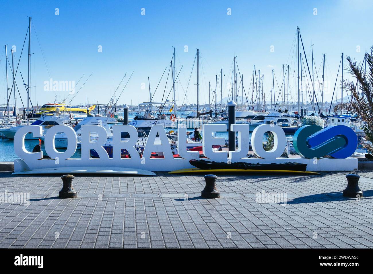 Panneau de ville de Corralejo avec planches de surf en dessous près de la marina, Corralejo, Fuerteventura, Îles Canaries, Espagne. Banque D'Images