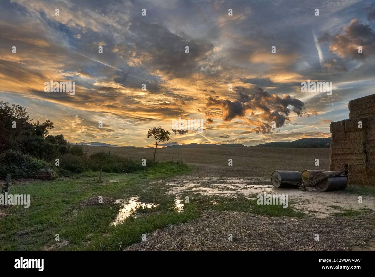 Paysage rural au coucher du soleil. Avec balles de champ et de paille après pluie. Ciel bleu avec nuages orange. Fin de l'automne. Zone agricole Chocholna, Slovaquie Banque D'Images