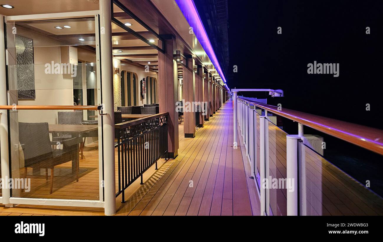 Une vue nocturne sur un balcon orné de tables et de chaises, exsudant une ambiance tranquille Banque D'Images