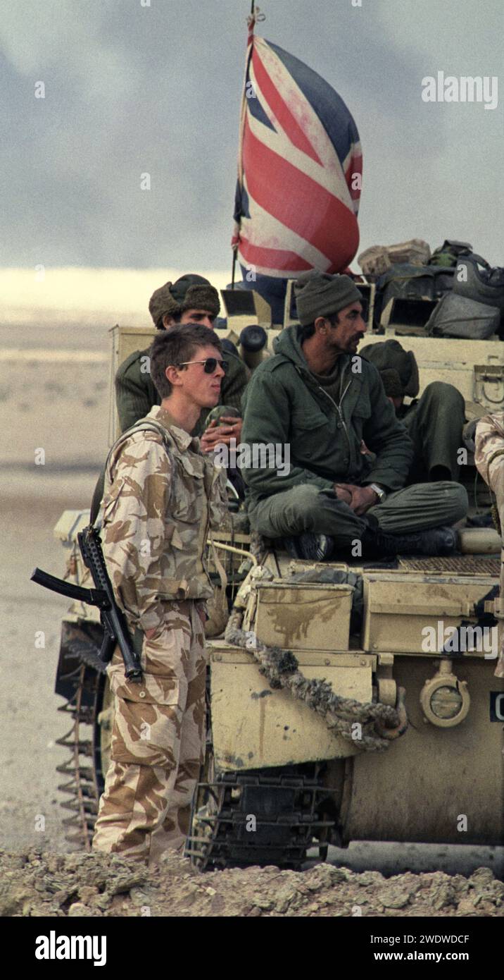 2 mars 1991 Au nord-est du Koweït, à côté de son char Schimitar, un soldat britannique des gardes du Dragoon de la Reine garde les Prisonniers de guerre irakiens. Banque D'Images
