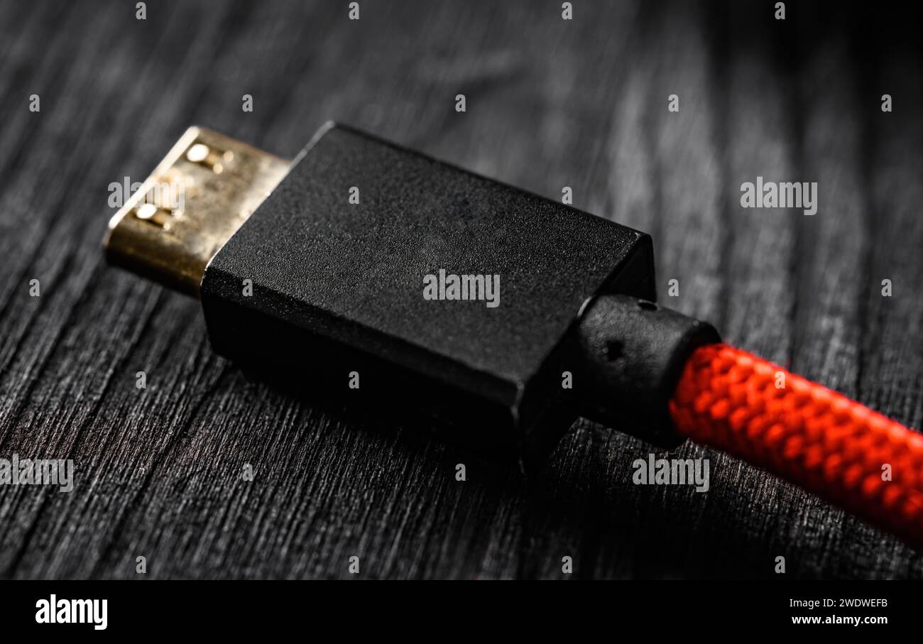 Fil rouge avec connecteur HDMI, sur une table sombre, vue rapprochée Banque D'Images