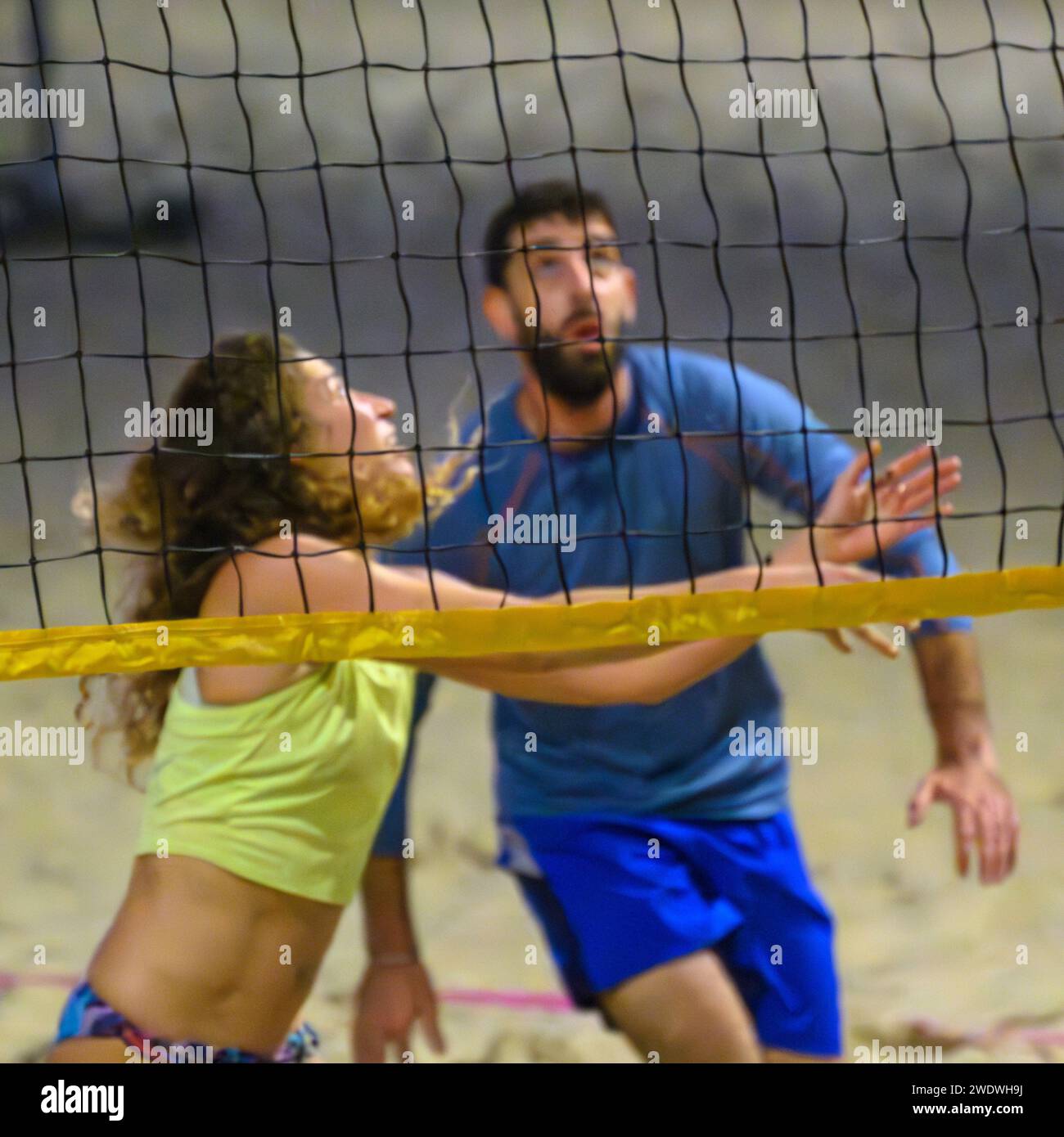 Un groupe d'amis jouant à une partie de Beach volley sur le sable de tel Aviv, plage méditerranéenne dans la soirée au crépuscule Banque D'Images