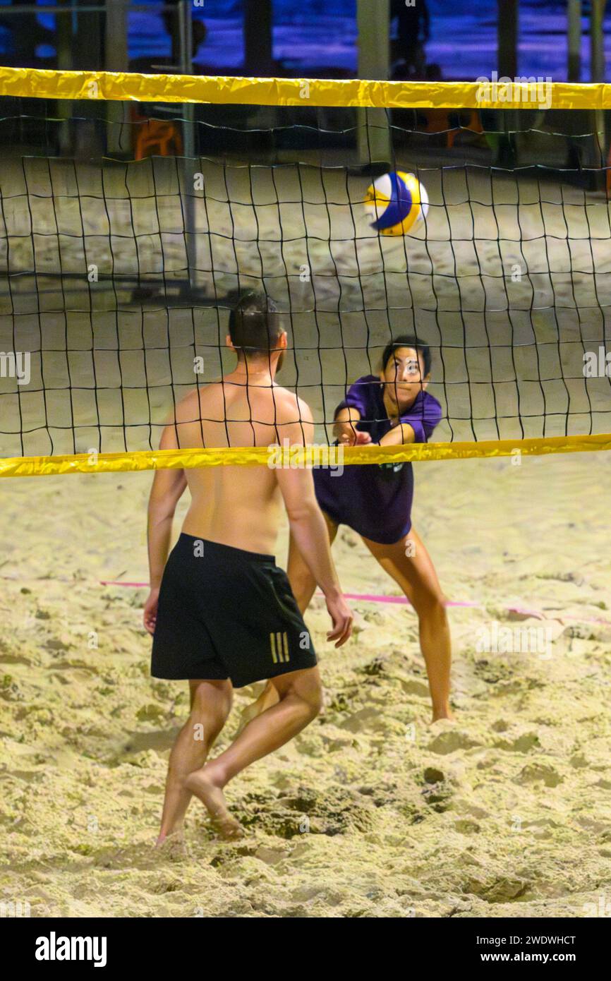 Un groupe d'amis jouant à une partie de Beach volley sur le sable de tel Aviv, plage méditerranéenne dans la soirée au crépuscule Banque D'Images