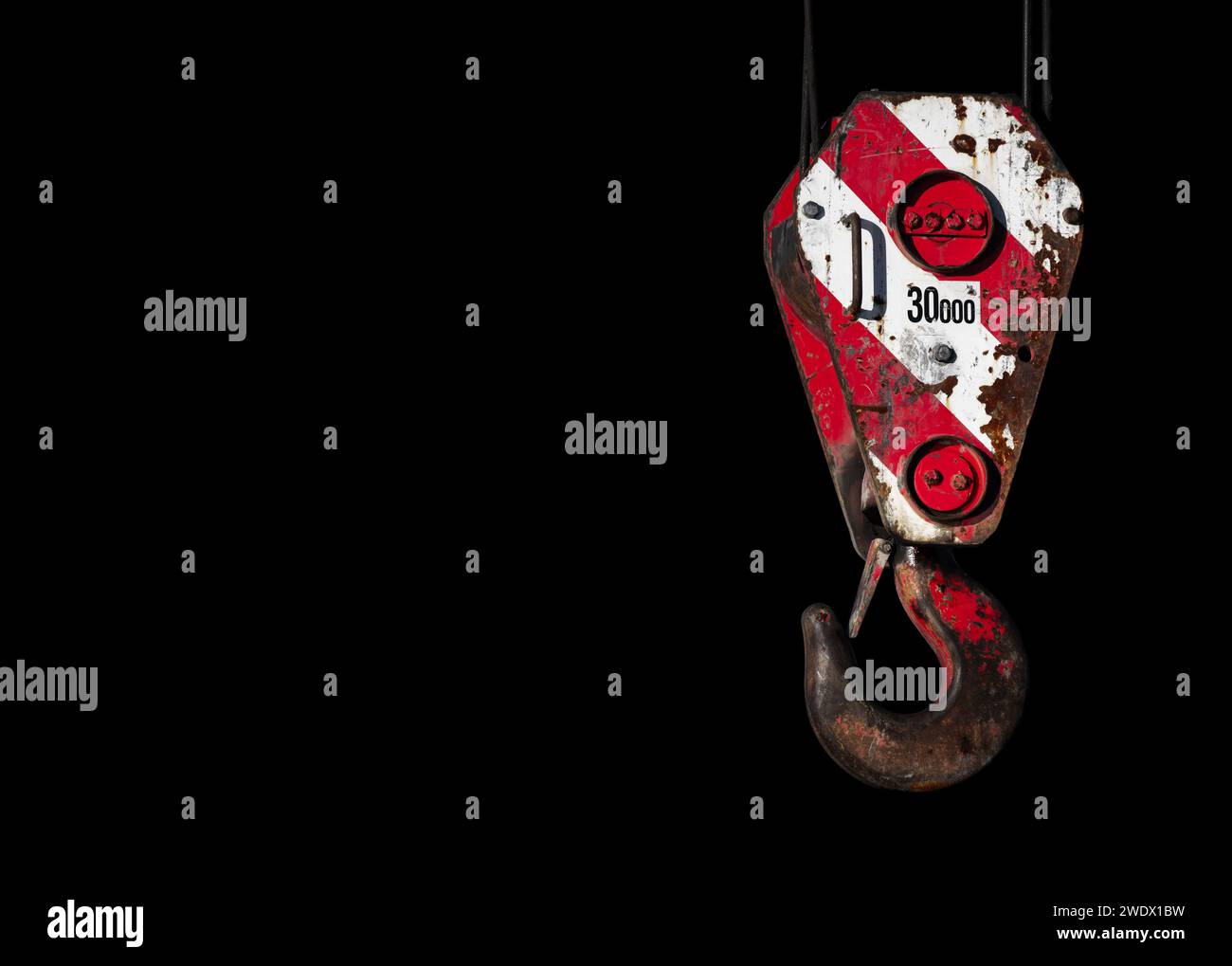 Crochet de grue avec motif d'avertissement blanc rayé rouge, photo rapprochée isolée sur fond noir Banque D'Images