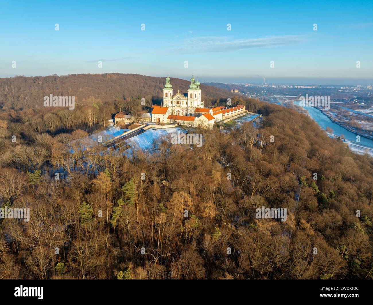 Monastère Camaldolese et église baroque dans le bois sur la colline à Bielany, Cracovie, Pologne, vue aérienne dans la lumière du coucher du soleil en hiver avec la Vistule Banque D'Images