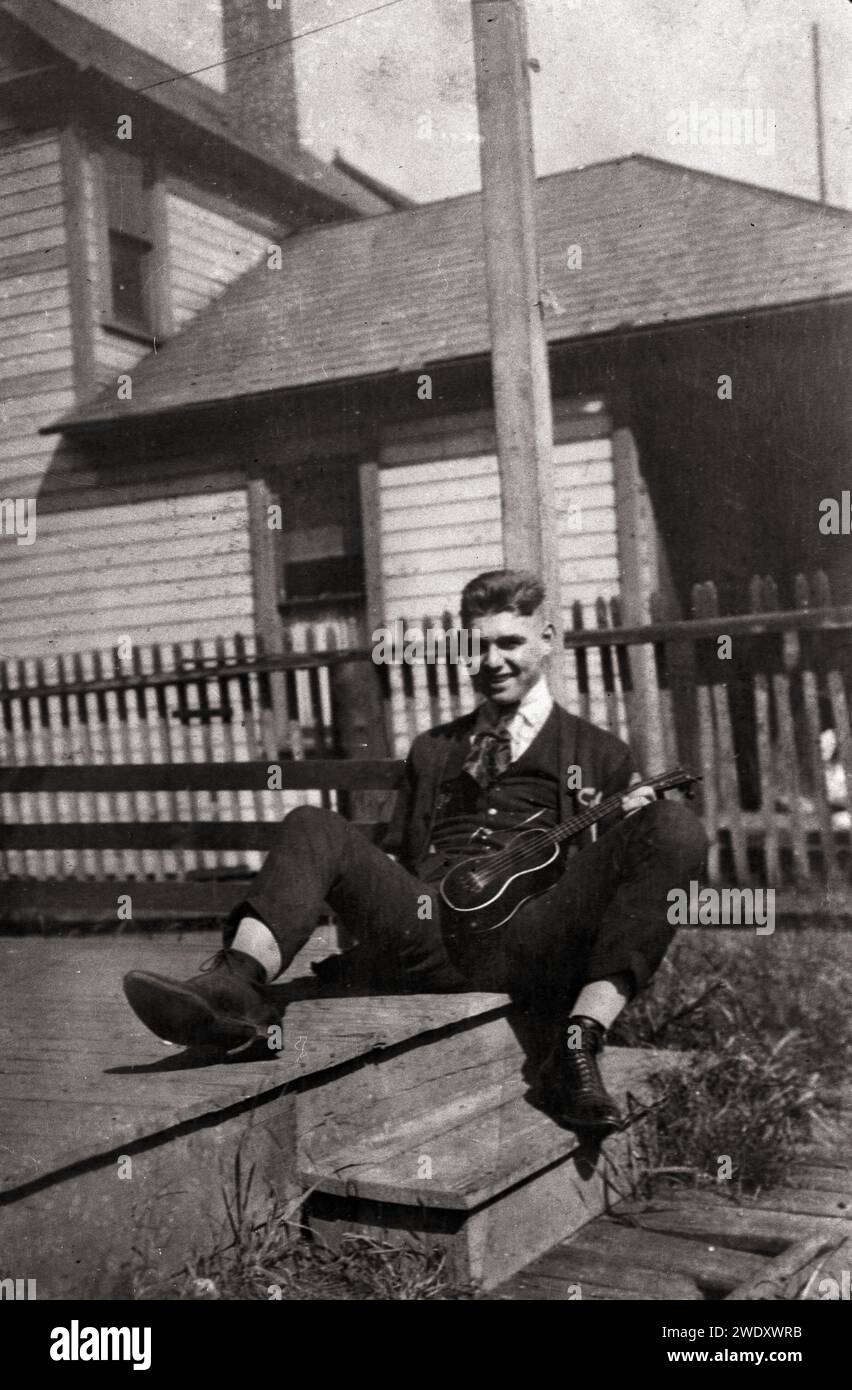 Jeune acteur et future star hollywoodienne, Clark Gable sur un porche avec ukulele, Ohio années 1920 Banque D'Images