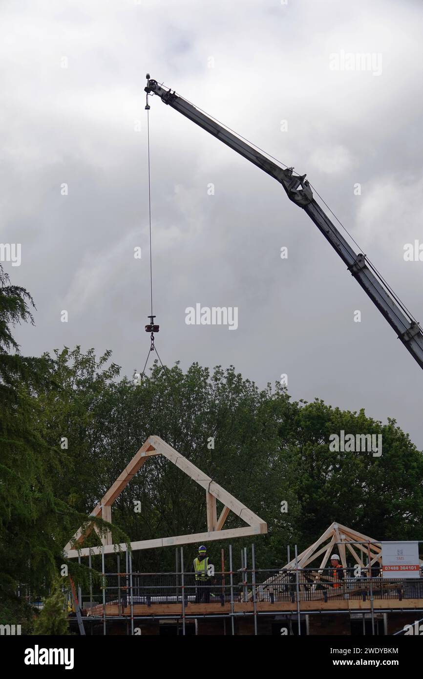 Fermes de toit installées par grue sur un chantier de construction d'un immeuble résidentiel Banque D'Images