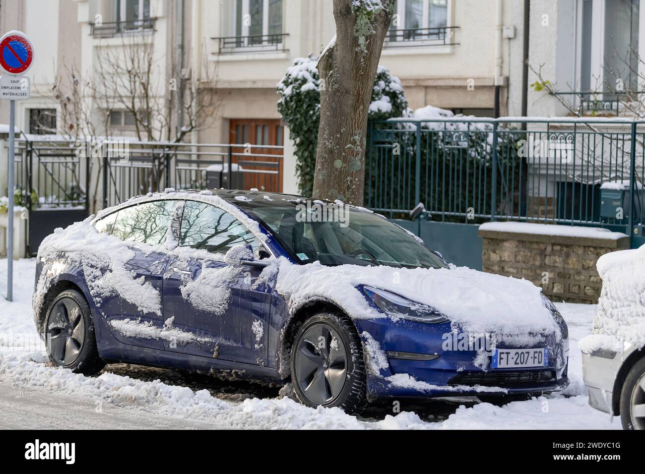Nancy, France - Bleu Tesla Model 3 garé dans la rue avec de la neige. Banque D'Images