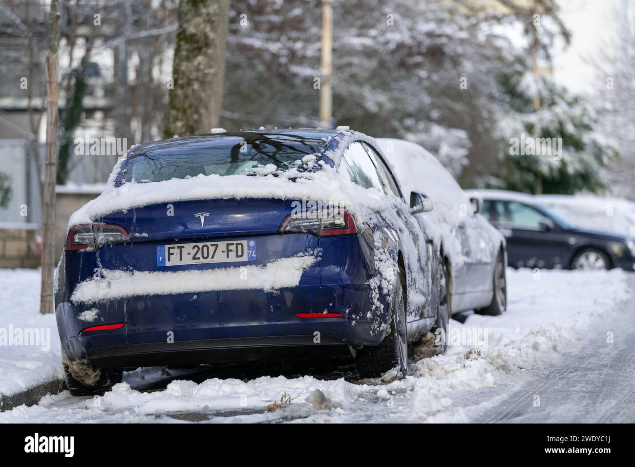 Nancy, France - Bleu Tesla Model 3 garé dans la rue avec de la neige. Banque D'Images