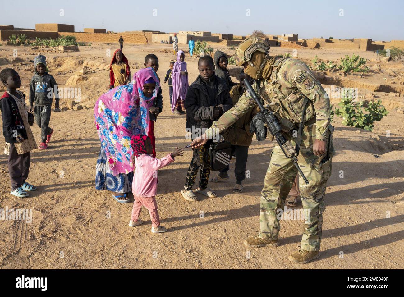 L’aviateur senior de l’Armée de l’Air Lorenzo Bennette remet des bonbons à un enfant près de la base aérienne 201 au Niger, le 6 janvier 2023. Banque D'Images