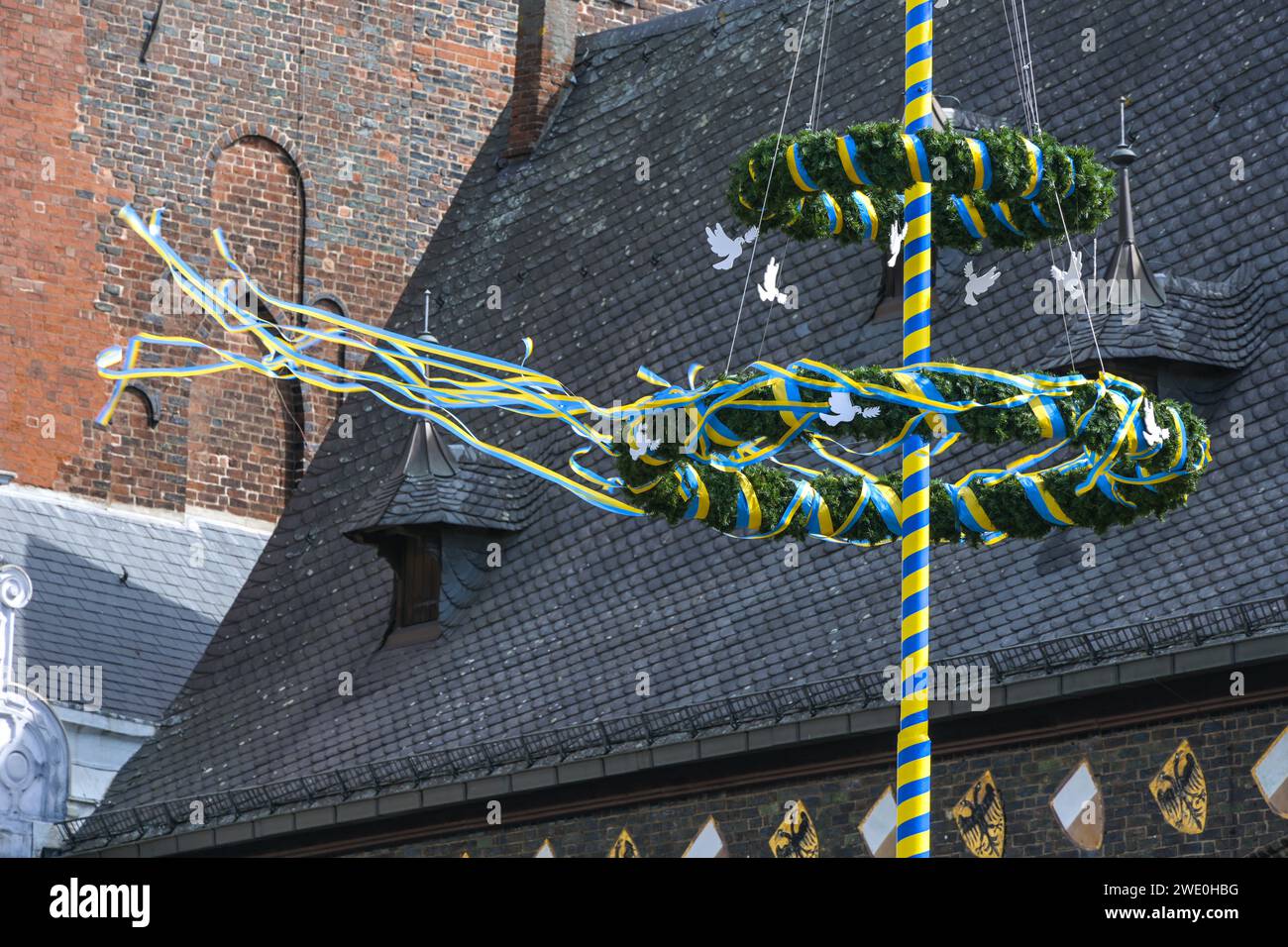 Maypole avec des colombes de paix blanches et des rubans jaunes bleus flottants, couleurs du drapeau de l'Ukraine, devant la mairie de Lubeck, Allemagne, mai 2022, Banque D'Images