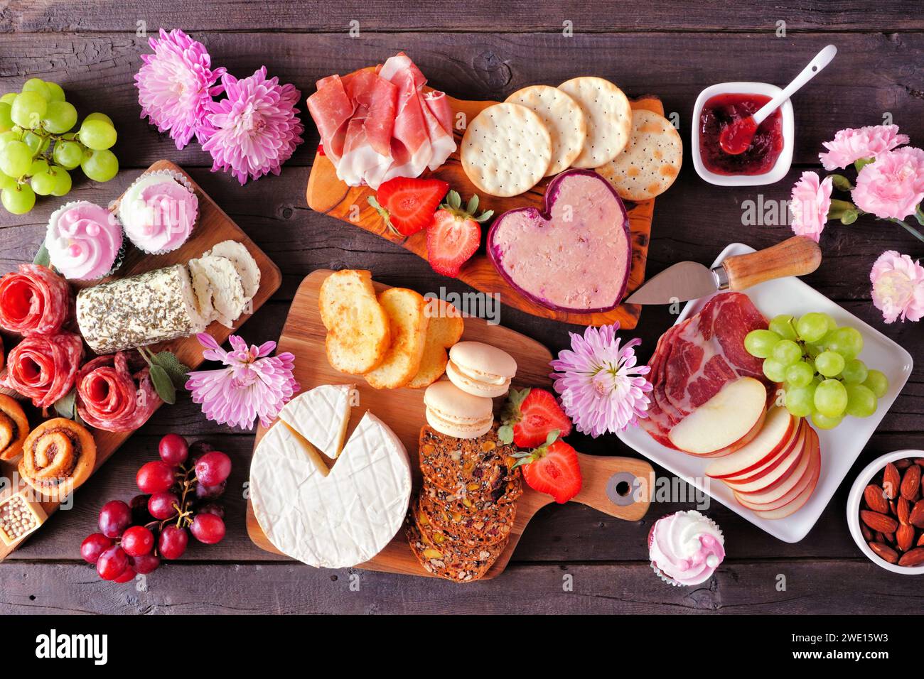 Scène de table de charcuterie de thème de fête des mères sur un fond de bois sombre. Assortiment de fromages, viandes, fruits et hors-d'œuvre sucrés. Vue de dessus. Banque D'Images