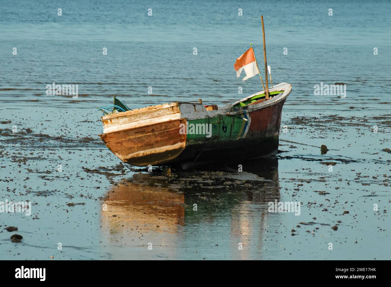 Un bateau de pêche avec un drapeau indonésien est bloqué sur la plage Banque D'Images