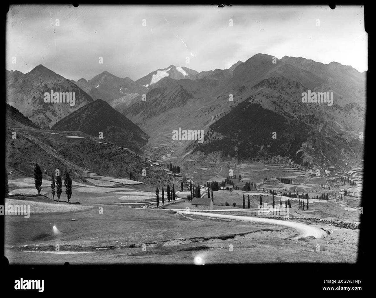 Alguns edificis i conreus a la vall de Sallent de Gállego i al fons els pics de los Infiernos. Banque D'Images