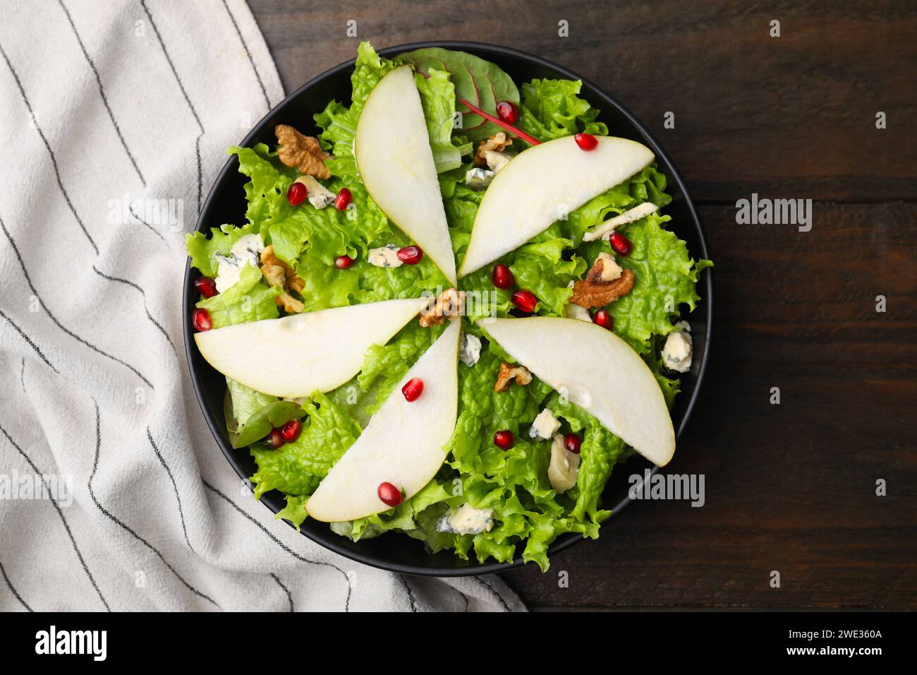Délicieuse salade de poires dans un bol sur une table en bois, vue de dessus Banque D'Images
