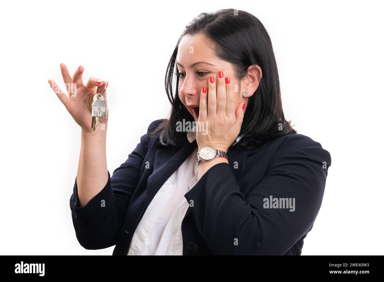 Surprise agent immobilier femme d'affaires en costume élégant-décontracté tenant les clés pour la maison faisant l'expression choquée et le geste palmier touchant la joue isolat Banque D'Images