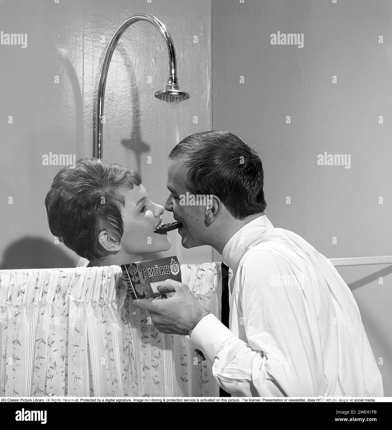 Chocolat Mazetti. Un jeune couple joue dans une publicité pour le chocolat noir Mazetti. Ils partagent un morceau de chocolat quand elle est sous la douche. Suède 1962. Kristoffersson réf CZ54 Banque D'Images