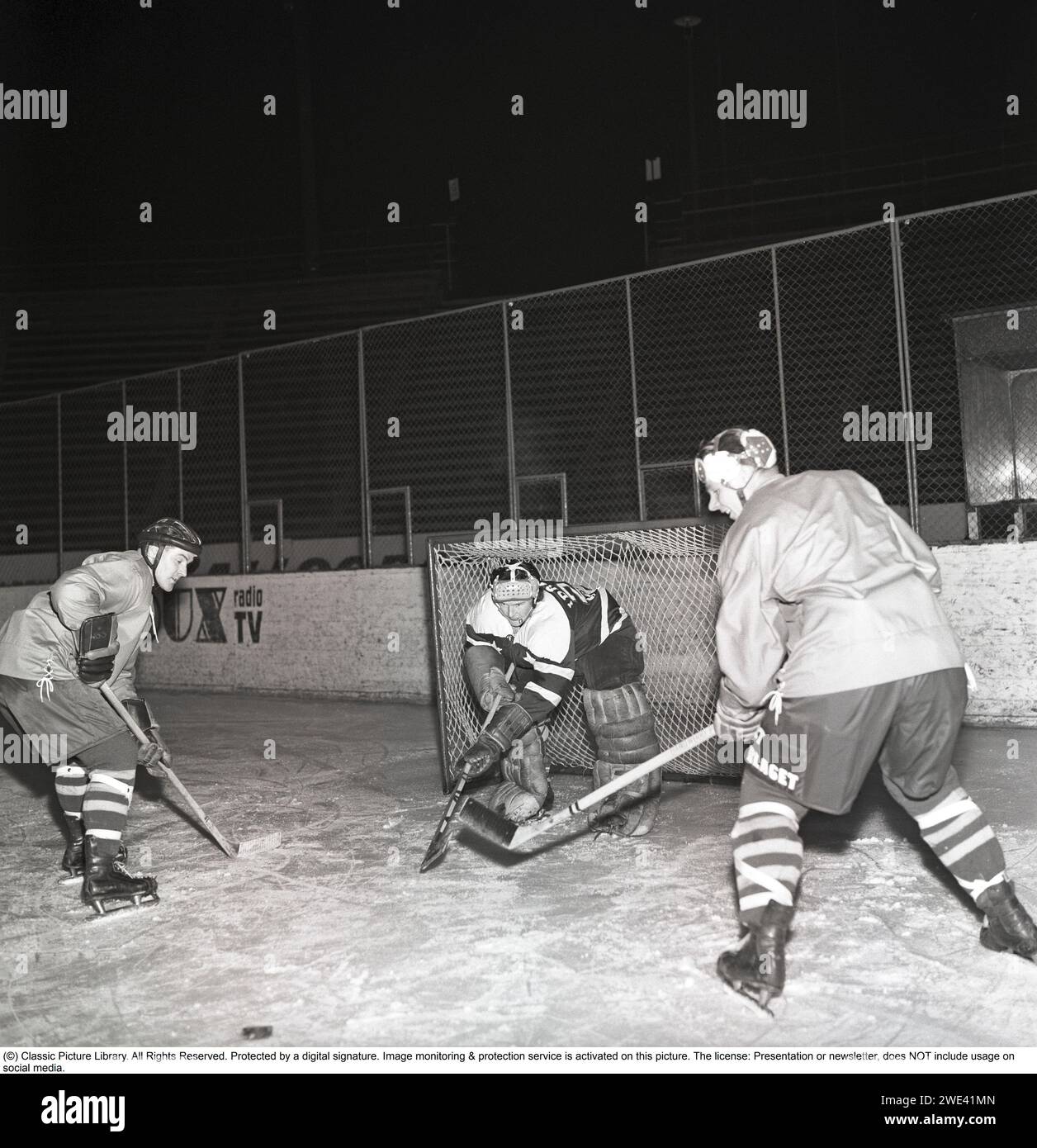 Hockey sur glace dans les années 1950 Un gardien de but et deux joueurs sur la patinoire de hockey sur glace. 1959. Kristoffersson réf. CL20-3 Banque D'Images