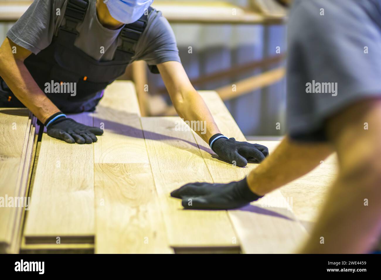 ouvriers assemblant le plancher en bois dans l'usine de transformation du bois Banque D'Images