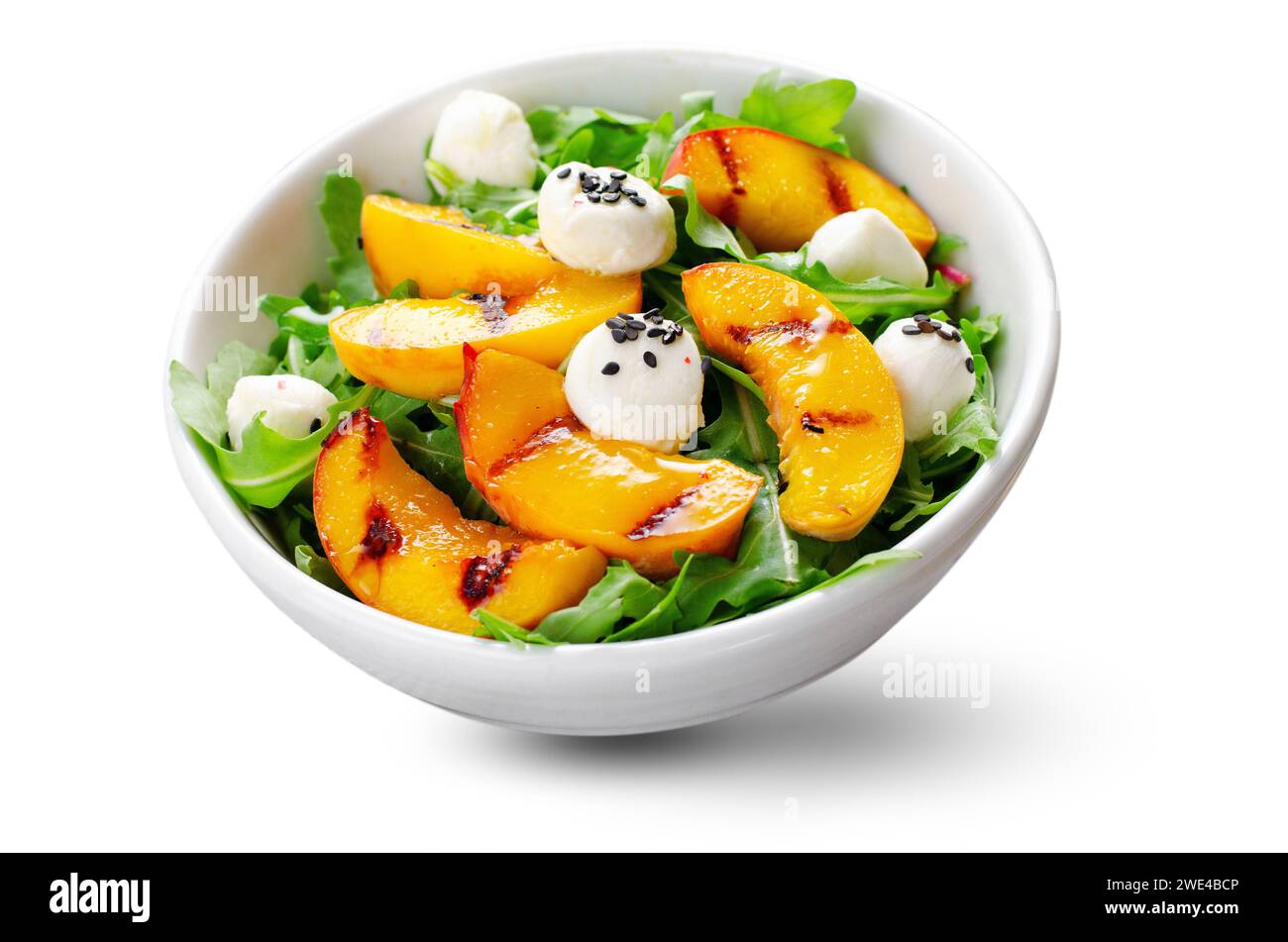 Salade de pêche grillée avec perles de fromage roquette et mozzarella sur fond blanc isolé Banque D'Images