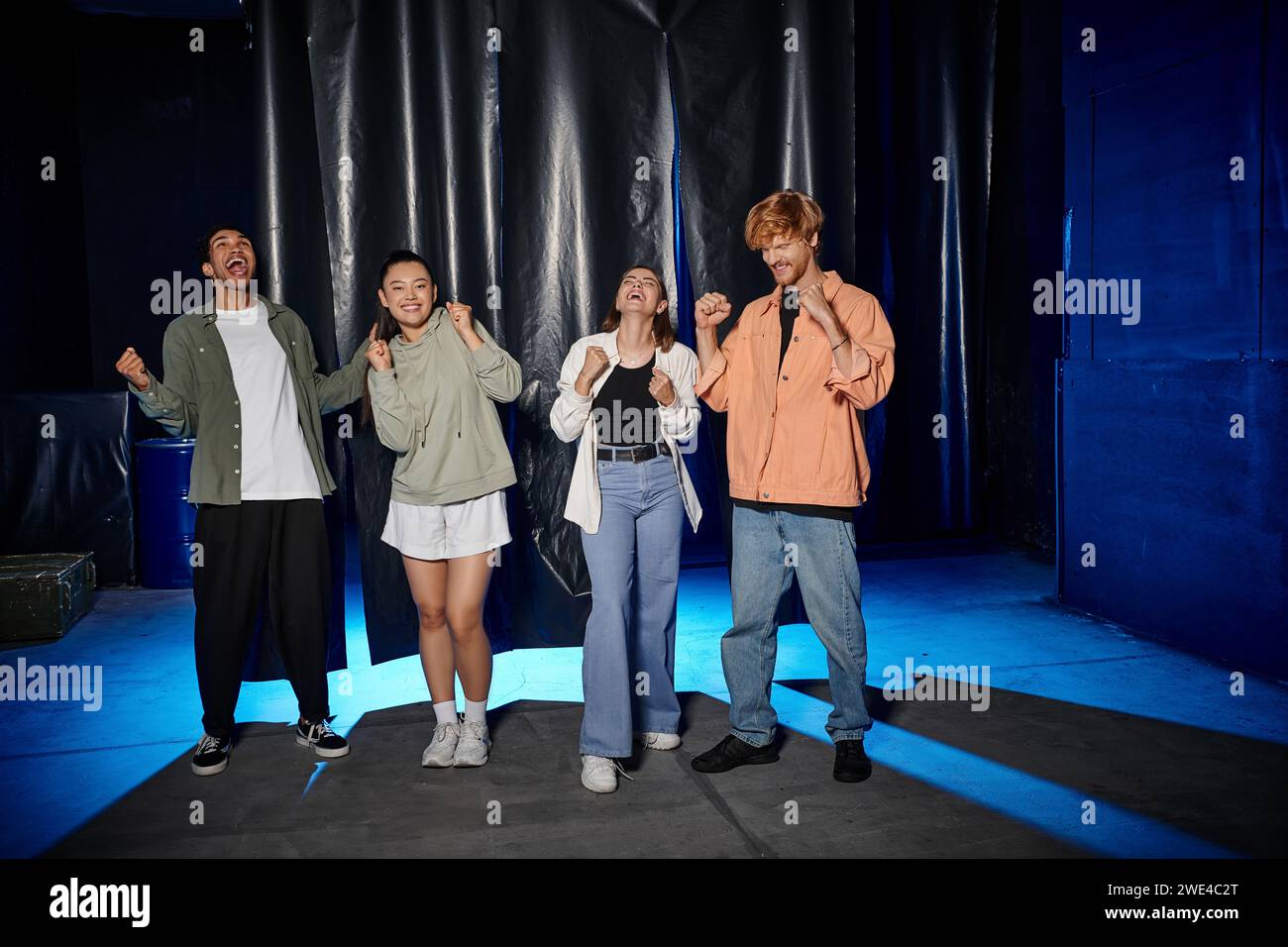 groupe de quatre amis interraciaux célébrant le succès dans un défi de salle d'évasion, réjouissez-vous Banque D'Images