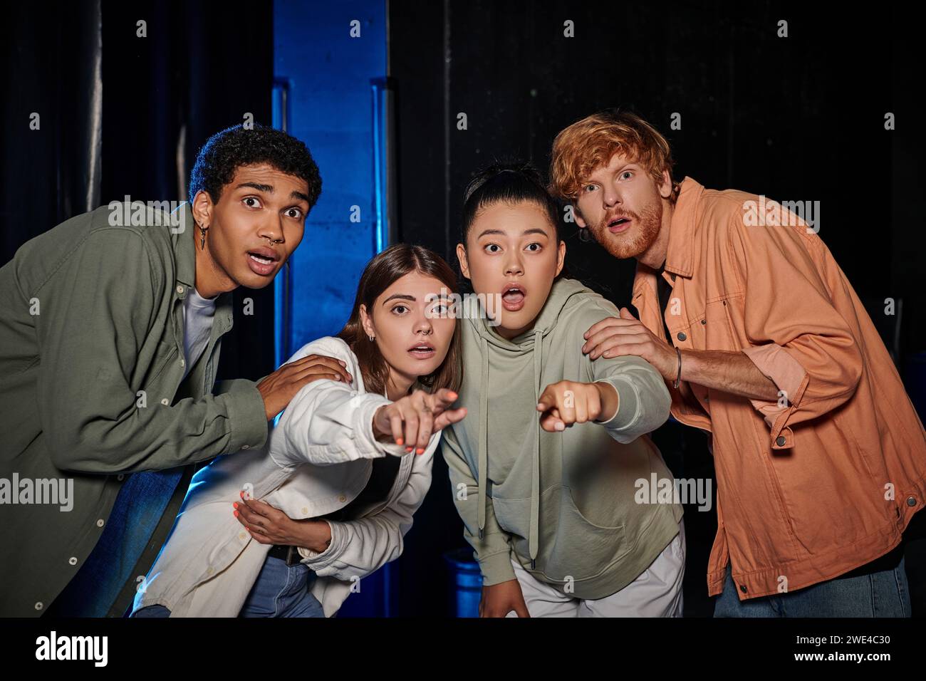 groupe de quatre amies étonnées découvrant un indice dans la salle d'évasion, les femmes pointant du doigt Banque D'Images