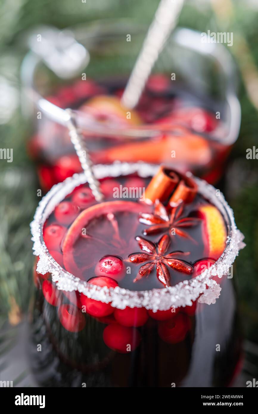 Gros plan de vin chaud en verre avec décoration sucrée, bâtonnets de cannelle et étoiles d'anis préparés pendant les vacances de Noël. Photographie de nourriture et de boissons Banque D'Images