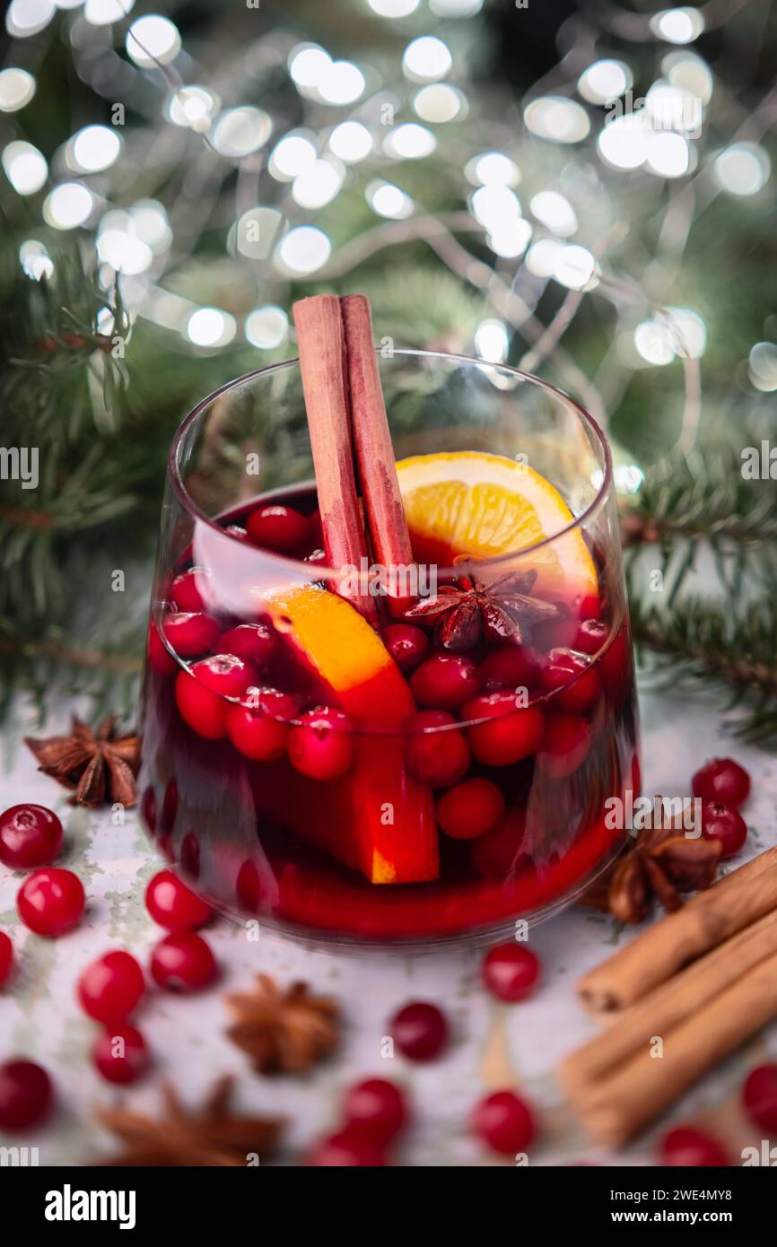 Vin chaud de Noël en verre avec lumières de Noël et brindilles de sapin sur fond Banque D'Images