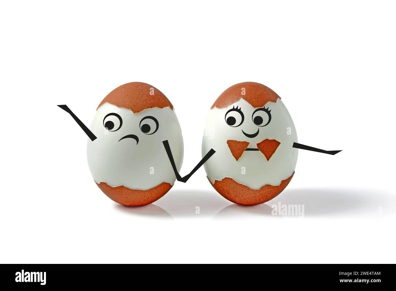 Deux œufs de poule avec des coquilles et des visages dessinés et des mains isolés sur un fond blanc. Paire d'œufs décorée comique pour un mariage sous la forme d'un garçon Banque D'Images