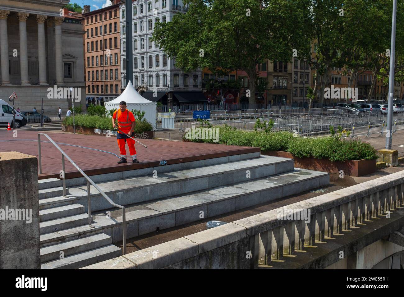 Lyon, France, 2023. Un ouvrier de la ville en vêtements haute visibilité nettoie les marches place Paul Duquaire, devant la Cour d'appel de Lyon Banque D'Images