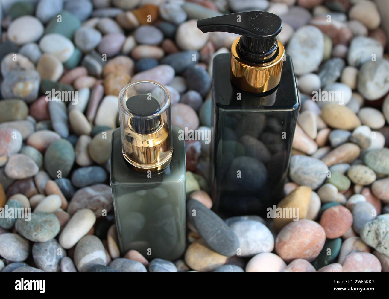 Lotion de soin de la peau et baume en bouteilles sur galets de mer Banque D'Images