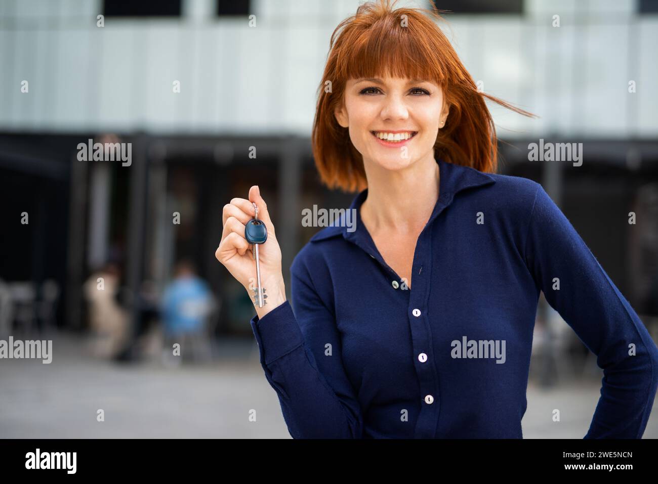 Femme d'affaires montrant les clés de son nouveau bureau, concept immobilier Banque D'Images