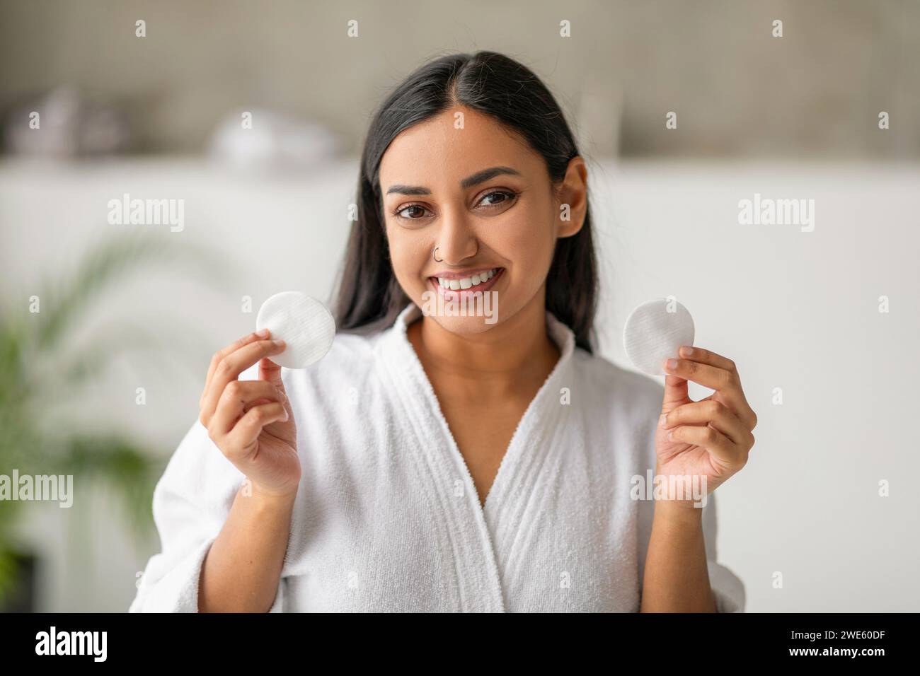 Gros plan de jolie jeune femme indienne montrant des tampons de coton Banque D'Images