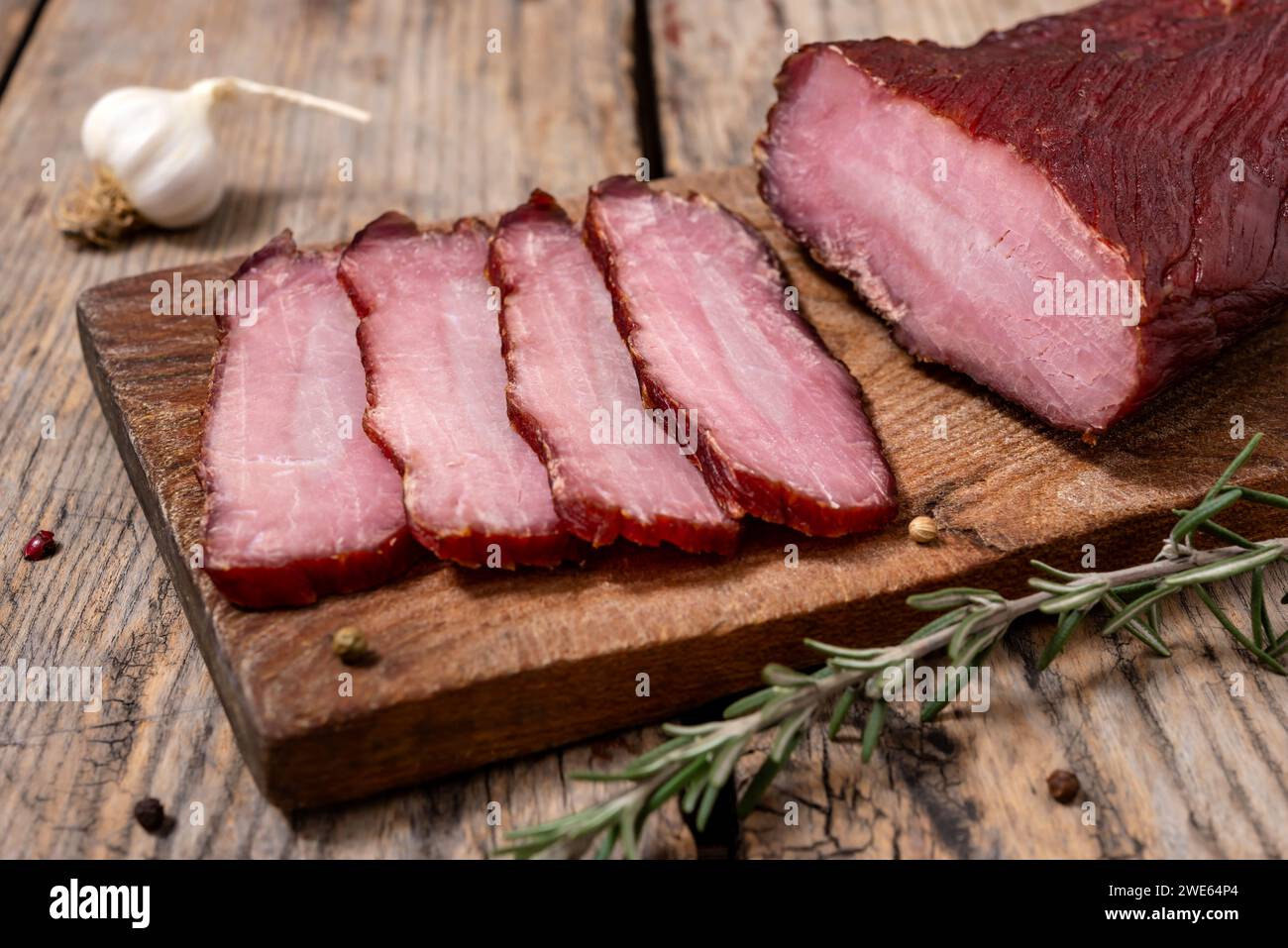 Planche à découper avec de la viande séchée et des épices sur une table en bois. Mise au point sélective. Banque D'Images