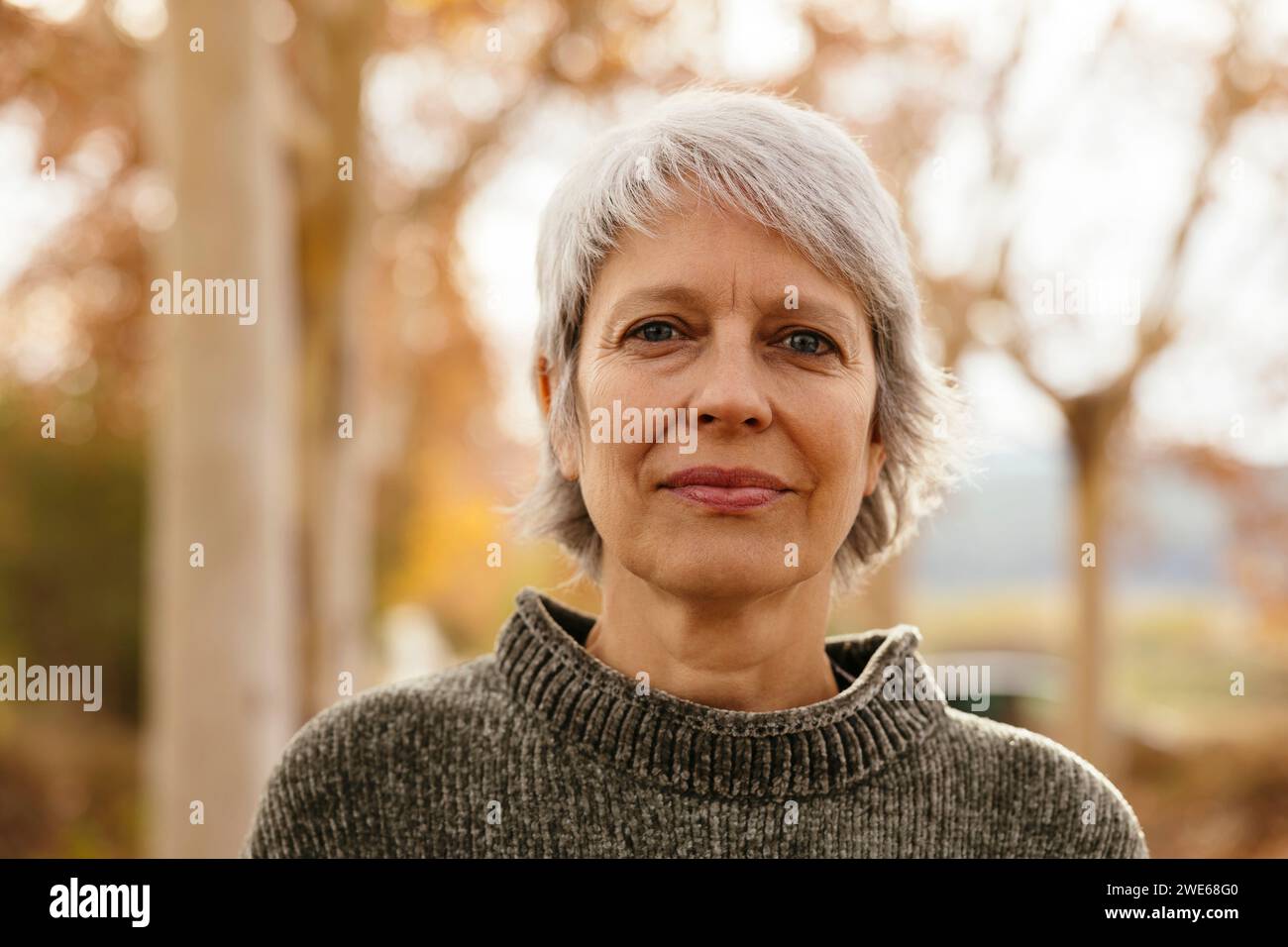 Femme mûre souriante avec les cheveux gris courts Banque D'Images