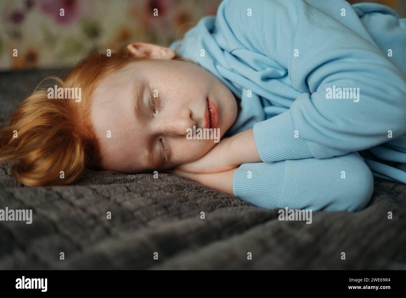 Fille de Redhead dormant sur le lit Banque D'Images