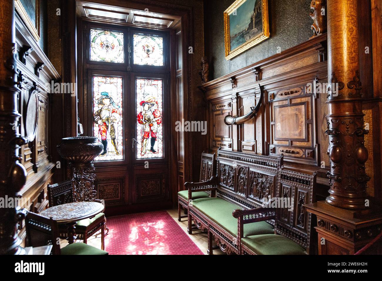 Intérieur en bois orné et vitrail de la salle d'attente à l'extérieur de l'étude du roi Carol au château de Peles, Sinaia, Roumanie Banque D'Images